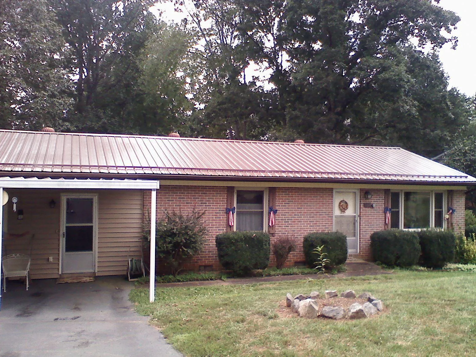 Bronze metal roof and carport on a brick ranch home — Roof Repair work by our crew in Albion